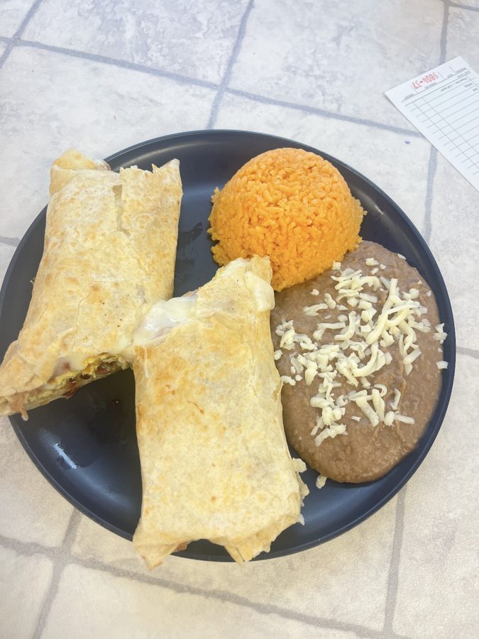 Burrito cut in half served with rice and beans