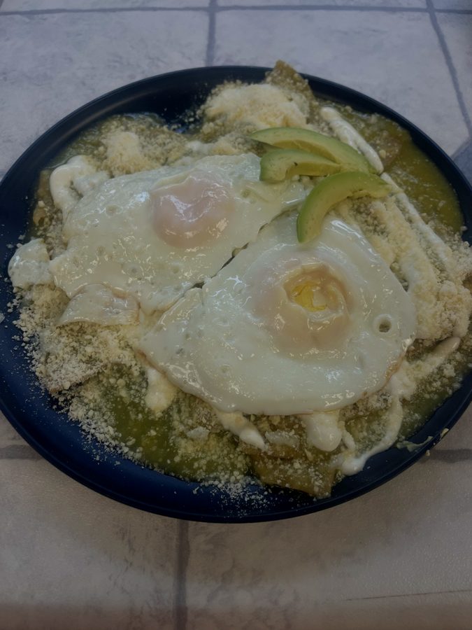 Green chilaquiles topped with fried eggs, crema, cotija and avocado