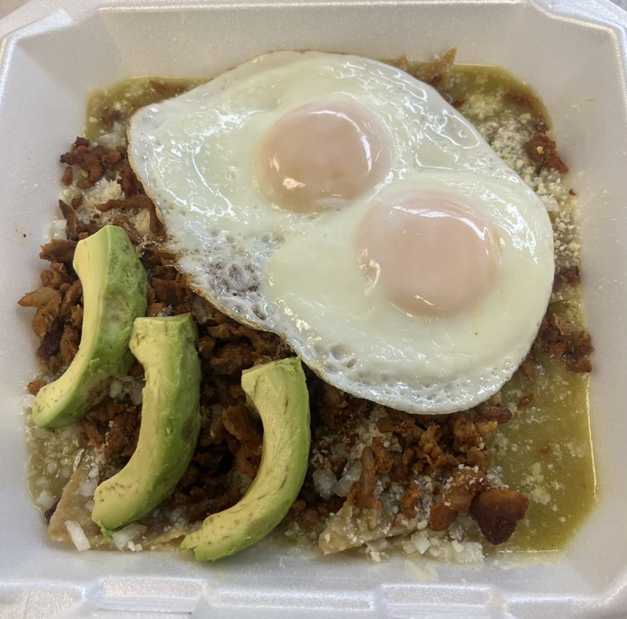 Green chilaquiles topped with meat, fried eggs and avocado