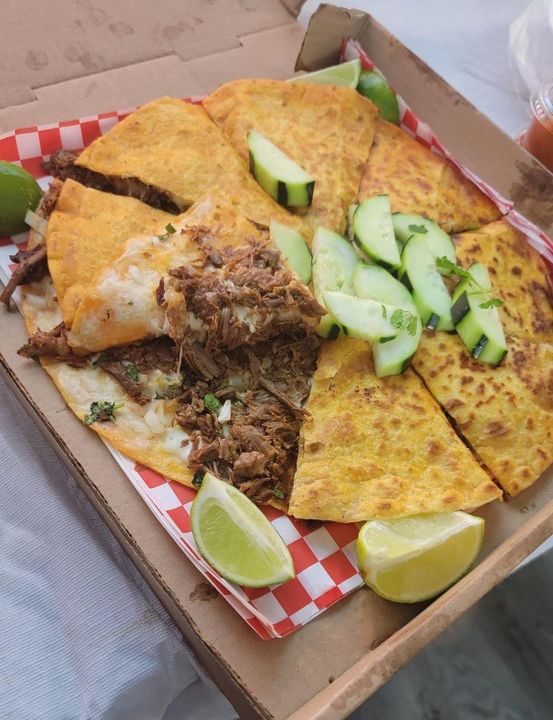 Pizzabirria wedges in a box with cucumber and lime